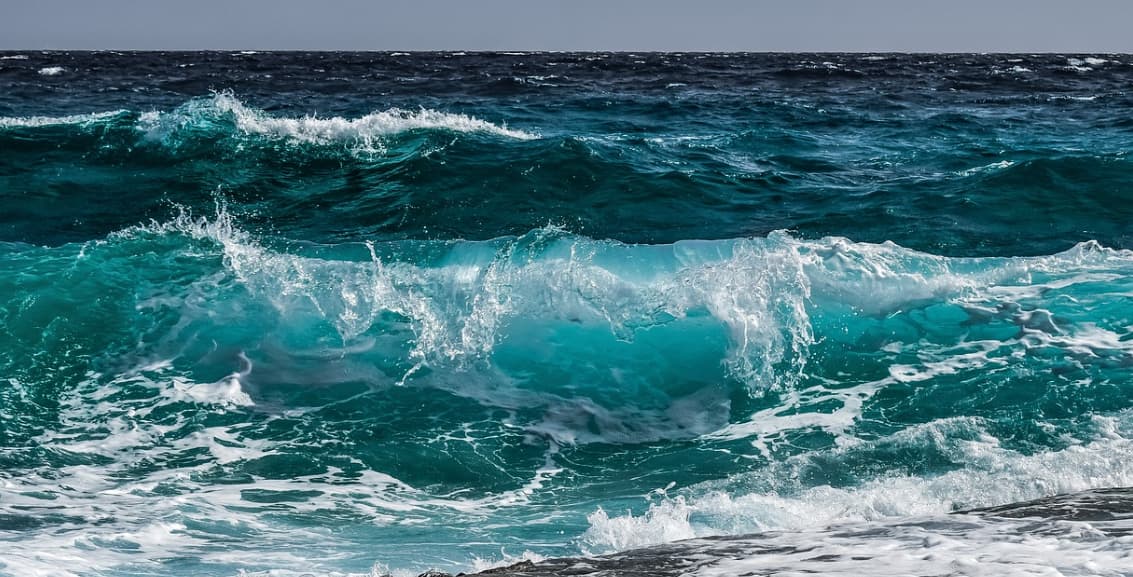 Vivid ocean wave cresting with white foam