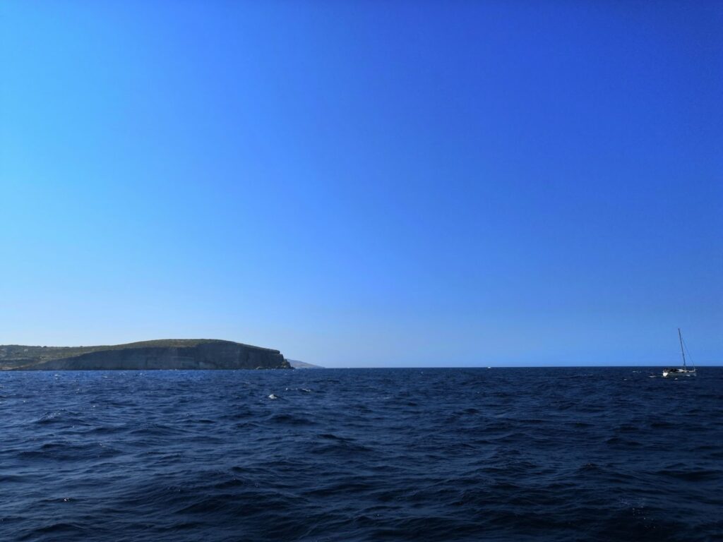 Wavy sea and blue sky with mountain in horizon