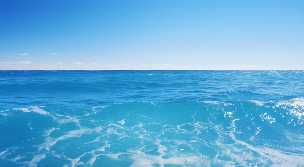 Clear blue ocean waves under a bright, cloudless sky