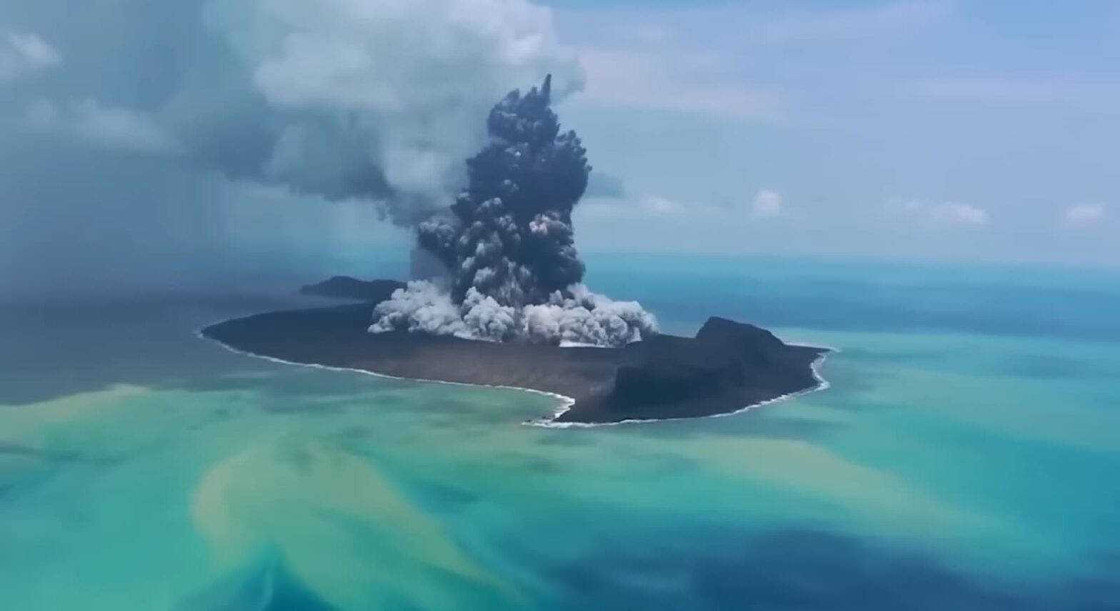 A volcanic eruption on an island surrounded by blue waters