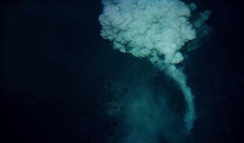 An underwater volcanic eruption creating a plume of smoke