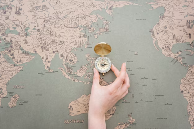Hand placing compass on world map